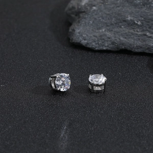 Makro-Detail von rund geschliffenen Zirkonia-Magnetohrringen mit silberner Vier-Krallen-Fassung