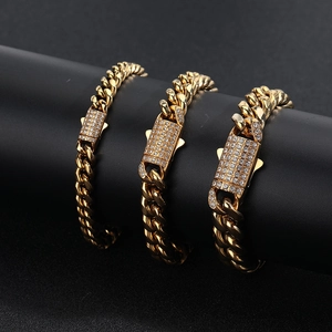 Detailansicht von drei goldenen Panzerarmbändern mit Zirkonia-besetzten Verschlüssen auf Schwarz