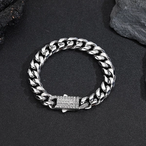 Detail eines silbernen Panzerarmbands mit Strass-Schnalle auf dunklem Steingrund