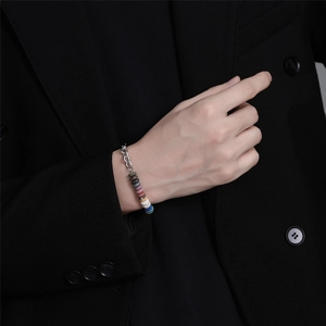 Detailansicht eines Titanstahl-Kettenarmbands mit bunten Vulkansteinringen am Handgelenk