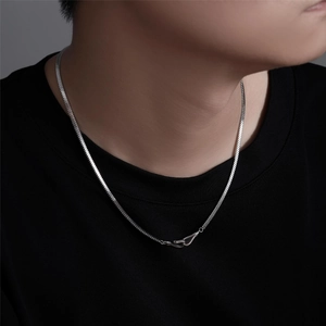 Close-up of silver snake chain necklace with unique hook clasp on black T-shirt