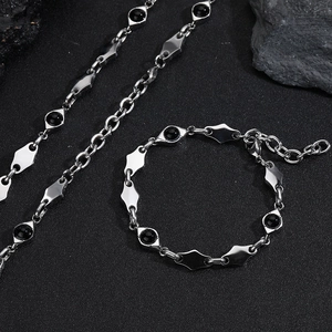 Detailed view of stainless steel rhombus links and black beads of the jewelry set
