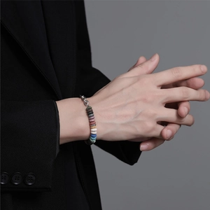 Schickes Armband aus Titanstahl mit bunten Lavasteinperlen an einem männlichen Modell