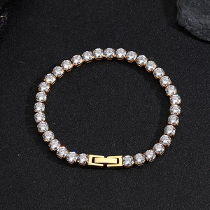 Gros plan du bracelet tennis doré avec pierres de zircone AAA sur texture noire
