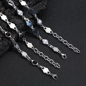 Detail of diamond-cut titanium steel chains with pearl beads and lobster clasp closure