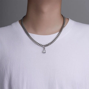 Détail d'un collier à mailles cubaines argentées avec pendentif en zircon sur t-shirt