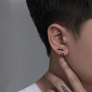 Close-up of men's matte black water drop stud and minimalist hoop earrings on model ear