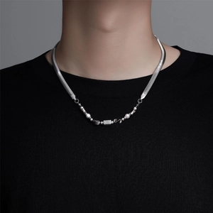 Close-up of titanium steel snake chain necklace with pearl and zircon detail on a model