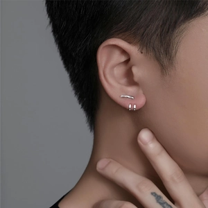 Silver teardrop stud and hoop earrings set worn by a model in a minimalist style