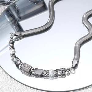 Detailed macro view of silver snake chain with pearls and zircon-encrusted rectangular charms