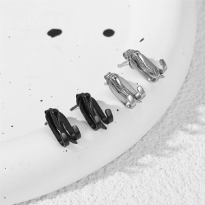 Macro view of minimalist water drop claw earrings in black and silver metallic finish