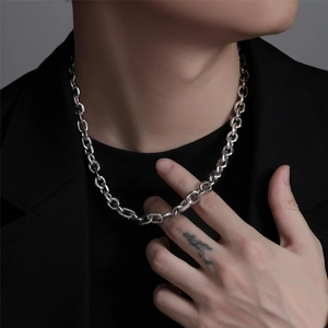 Detail of chunky silver chain necklace with zircon pavé links on a black suit