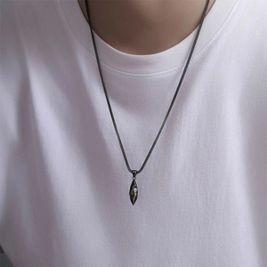 Gros plan du pendentif météorite gravé avec motif soleil sur un t-shirt blanc