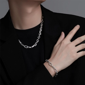 Geometric zircon necklace and bracelet set in silver finish worn on black blazer