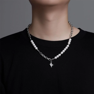Dettaglio della collana con ciondolo a stella, perle e zircone indossata al collo