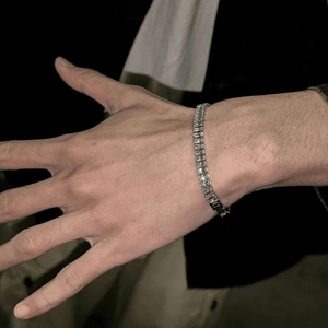 Gros plan d'un bracelet tennis en acier inoxydable avec zircons carrés sur un poignet