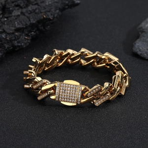 Gros plan d'un bracelet gourmette doré serti de diamants sur une surface sombre texturée
