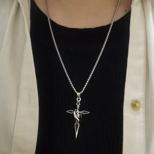 Collier avec pendentif croix épée en acier argenté sur mannequin montrant un style hip-hop