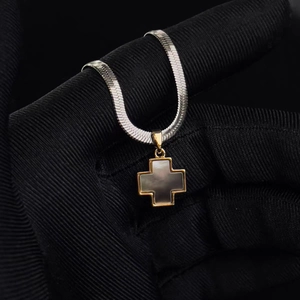 Close-up of titanium steel cross pendant with dark mother of pearl and snake chain