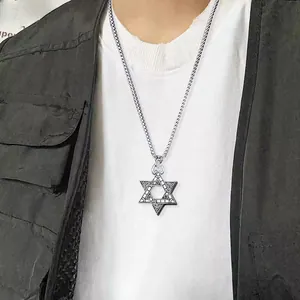 Detail of vintage silver hexagram pendant with intricate engraving on a male model
