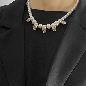 Hip hop pearl necklace featuring crystal skull charms and vintage gold accents on model