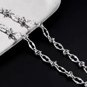 Detail shot of silver barbed wire link necklace in punk street style for men