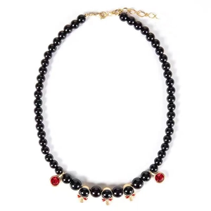 Detail of hip hop beaded necklace featuring gold skulls and red gem pendants