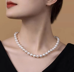 Close-up of elegant white round pearl necklace worn by a model as a clavicle choker