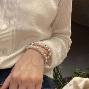 Elegant double-layered cream white pearl bracelet on a woman wrist for a minimalist look