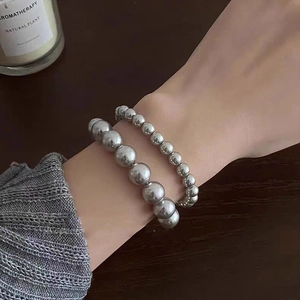 Detail of silver-toned double layered metal beaded bracelet worn on a woman wrist