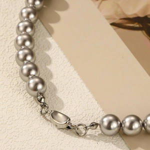 Detailed macro view of gray pearls and modern silver toggle clasp on a necklace