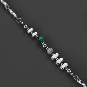 Detailed shot of titanium steel Mobius necklace with green stone and pavé beads