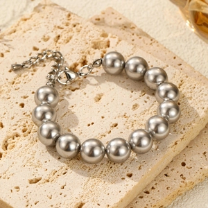 Detail view of large silver pearl necklace with adjustable lobster clasp on stone tray