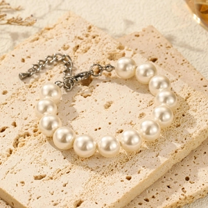 Detail view of smooth cream pearl necklace with silver lobster clasp and extension chain