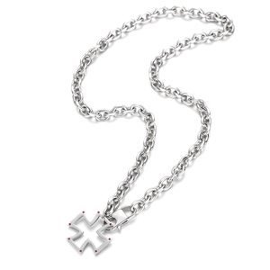 Détail du pendentif croix évidée en argent avec pierres rouges sur chaîne à maillons