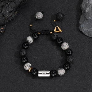 Macro shot of lava rock beads and silver monkey charm on adjustable braided bracelet