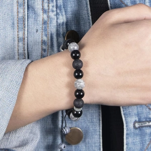Braided snowflake and volcanic stone bead bracelet for men and women on denim background