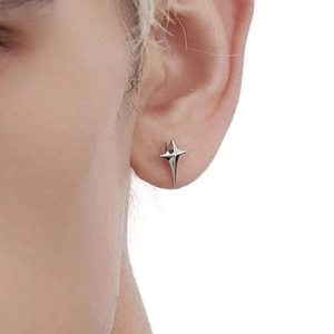 Close-up of a polished silver star-shaped stud earring worn on a model ear