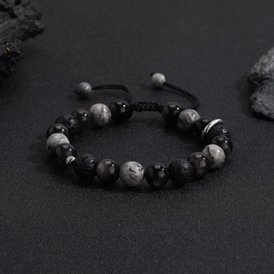 Macro shot of men's volcanic stone beaded bracelet with adjustable woven cord detail