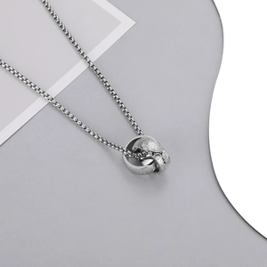 Detail of interlocking silver rings with intricate paisley patterns on box chain