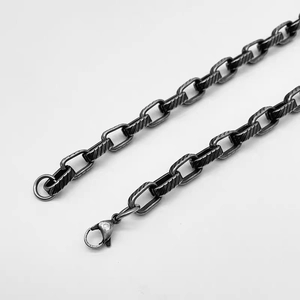 Detail shot of vintage titanium steel chain with engraved diagonal texture and lobster clasp