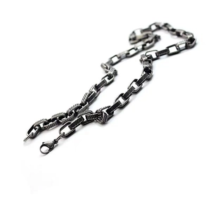 Macro detail of industrial style titanium steel necklace featuring textured twill links