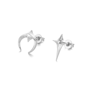 Macro shot of silver crescent moon and four-pointed star asymmetric stud earrings set