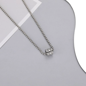 Macro detail of a silver box chain with a triple-ring cylinder pendant and cubic zirconia