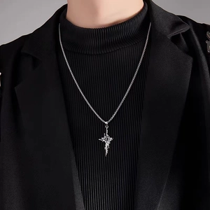 Detail of titanium steel gothic cross pendant with black stone on male model