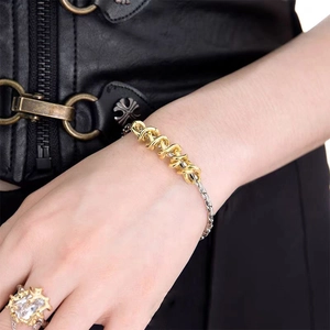Close-up of mixed silver and gold twisted metal chain bracelet with detailed punk texture