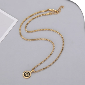 Detailed macro view of golden coin pendant necklace with daisy motif and twist rope chain