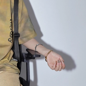 Close-up of gold and silver titanium cuban bracelets and rings on a female model