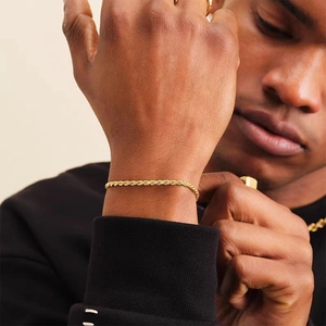 Primo piano di un bracciale a catena a corda intrecciata rifinito in oro 18K
