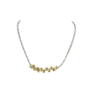 Macro detail of mixed gold and silver twisted chain necklace with sleek metal textures
